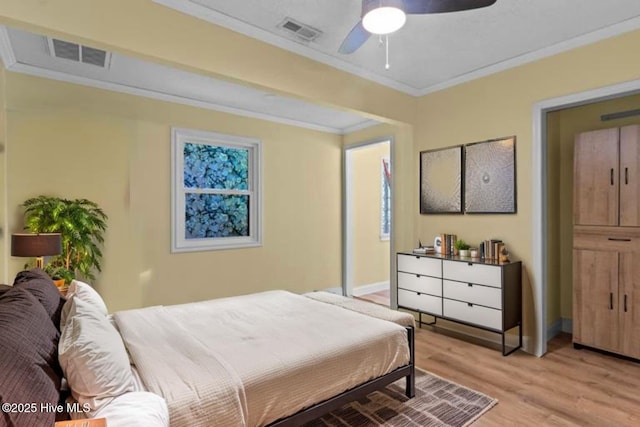 bedroom featuring light wood-style floors, crown molding, baseboards, and a ceiling fan
