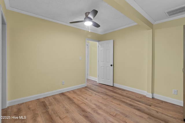 unfurnished bedroom with ornamental molding, wood finished floors, baseboards, and a ceiling fan