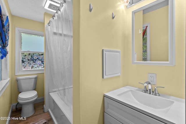 full bathroom featuring wood finished floors, toilet, vanity, shower / bath combo with shower curtain, and a textured ceiling