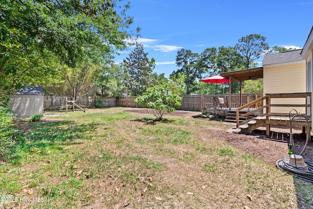 view of yard featuring a shed, an outdoor structure, and a wooden deck