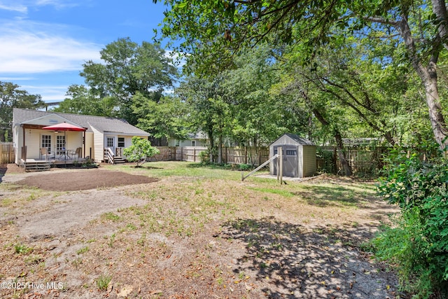 fenced backyard with a storage shed, an outbuilding, and a wooden deck