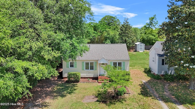 back of property with a storage unit, an outbuilding, and a lawn