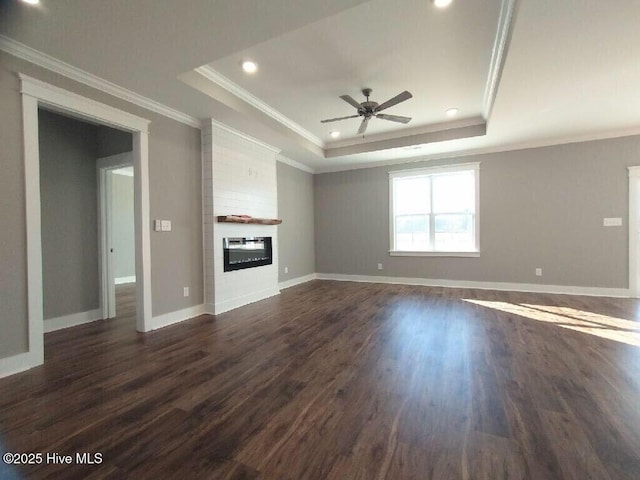351 Newell Rd, Snow Hill, NC 28580 - unfurnished living room featuring a raised ceiling, a ceiling fan, dark wood-style flooring, a large fireplace, and crown molding