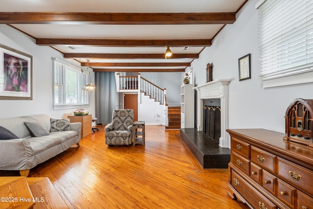 1306 W Church St, Elizabeth City, NC 27909 - living area with light wood-style floors, stairs, beam ceiling, and a fireplace with raised hearth