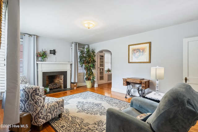 1306 W Church St, Elizabeth City, NC 27909 - living area featuring arched walkways, wood finished floors, and a fireplace with flush hearth