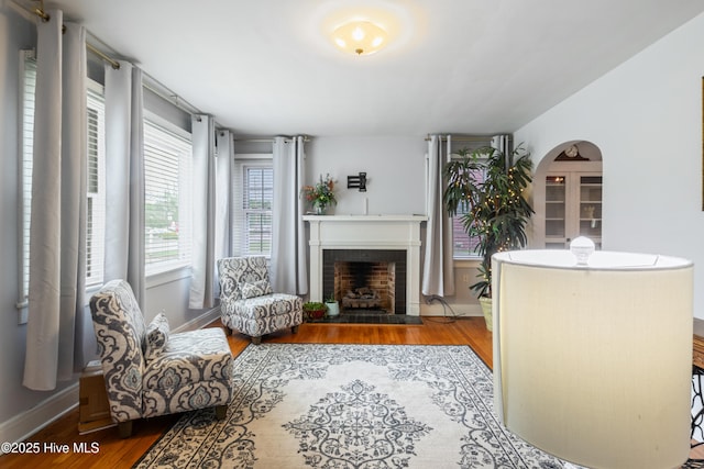 1306 W Church St, Elizabeth City, NC 27909 - living room with wood finished floors, a fireplace, arched walkways, and baseboards