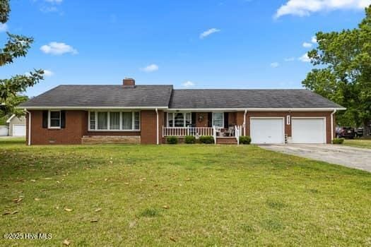 117 Arthur Rd, Beaufort, NC 28516 - ranch-style home featuring covered porch, a garage, a front lawn, concrete driveway, and a chimney