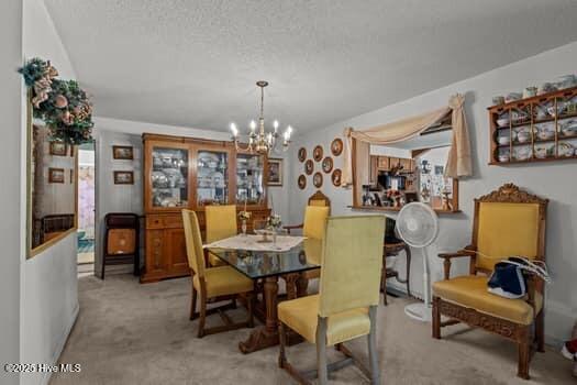 117 Arthur Rd, Beaufort, NC 28516 - dining space featuring carpet, a chandelier, and a textured ceiling