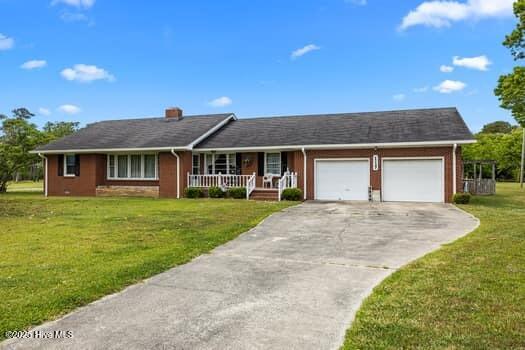 117 Arthur Rd, Beaufort, NC 28516 - ranch-style home with an attached garage, covered porch, concrete driveway, a front yard, and a chimney