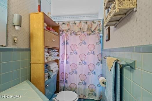 117 Arthur Rd, Beaufort, NC 28516 - full bathroom with wallpapered walls, tile walls, a wainscoted wall, curtained shower, and toilet