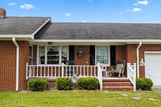 117 Arthur Rd, Beaufort, NC 28516 - doorway to property featuring brick siding, a garage, and a porch