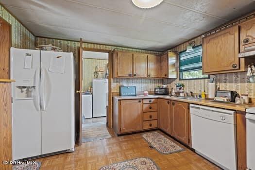 117 Arthur Rd, Beaufort, NC 28516 - kitchen featuring white appliances, washer / dryer, light countertops, and brown cabinetry