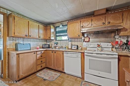 117 Arthur Rd, Beaufort, NC 28516 - kitchen featuring white appliances, under cabinet range hood, light countertops, a sink, and decorative backsplash