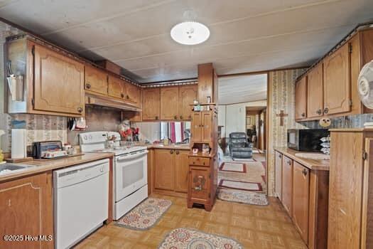117 Arthur Rd, Beaufort, NC 28516 - kitchen featuring white appliances, under cabinet range hood, brown cabinetry, and light countertops