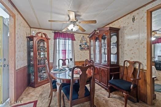 117 Arthur Rd, Beaufort, NC 28516 - carpeted dining room with wallpapered walls, a wainscoted wall, a ceiling fan, and ornamental molding