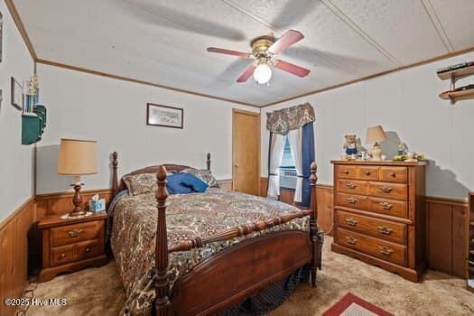 117 Arthur Rd, Beaufort, NC 28516 - carpeted bedroom with wainscoting, wood walls, a textured ceiling, and ceiling fan