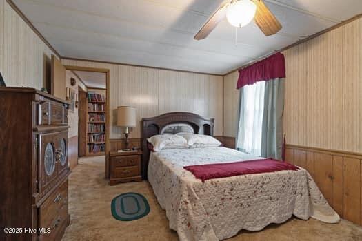 117 Arthur Rd, Beaufort, NC 28516 - bedroom with wood walls, light carpet, and ceiling fan