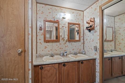 117 Arthur Rd, Beaufort, NC 28516 - full bath with wallpapered walls, double vanity, and crown molding