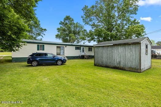 117 Arthur Rd, Beaufort, NC 28516 - rear view of property featuring an outdoor structure, a lawn, and a storage shed