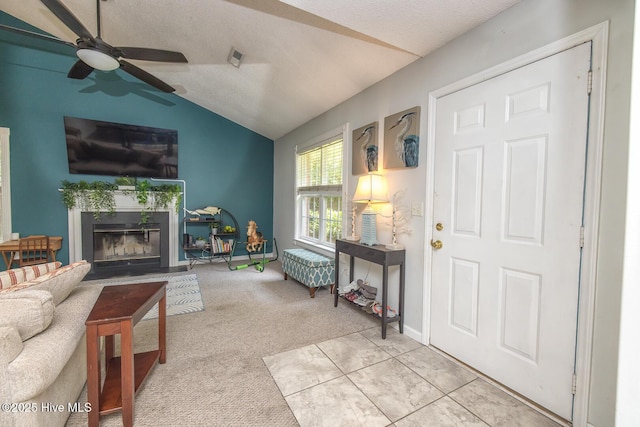 1009 Steeplechase Rd, Wilmington, NC 28412 - living room featuring a fireplace with flush hearth, a ceiling fan, vaulted ceiling, and light carpet