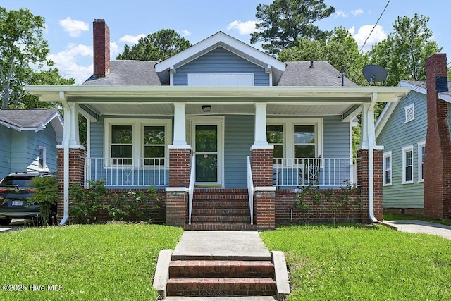 1912 Nun St, Wilmington, NC 28403 - bungalow-style house with a porch, a front yard, and a shingled roof