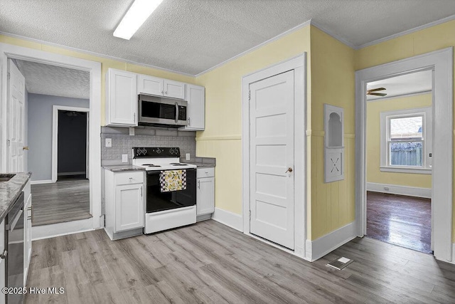 1912 Nun St, Wilmington, NC 28403 - kitchen featuring stainless steel appliances, light wood-type flooring, a textured ceiling, crown molding, and backsplash