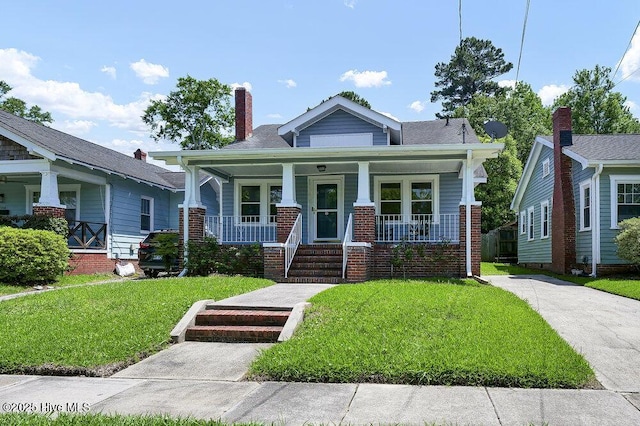 1912 Nun St, Wilmington, NC 28403 - view of front of house with a porch, a front lawn, and a chimney