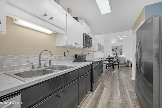 4602 Song Sparrow Ct, Wilmington, NC 28412 - kitchen with stainless steel appliances, a sink, white cabinets, and light countertops