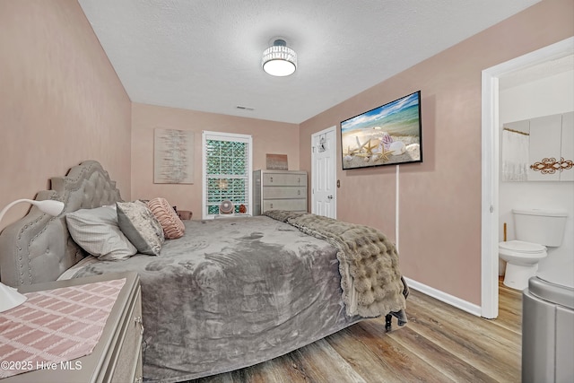 4602 Song Sparrow Ct, Wilmington, NC 28412 - bedroom featuring wood finished floors, baseboards, and connected bathroom