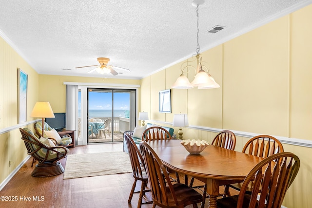 28 E First St Unit 4B, Ocean Isle Beach, NC 28469 - dining space with ornamental molding, wood finished floors, a textured ceiling, and ceiling fan