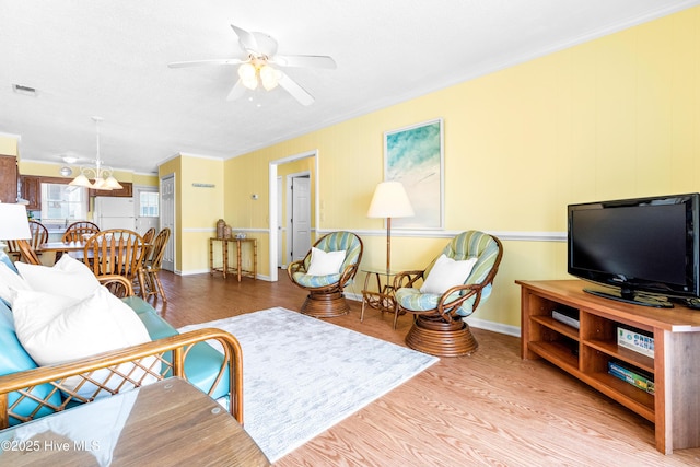 28 E First St Unit 4B, Ocean Isle Beach, NC 28469 - living area with crown molding, wood finished floors, ceiling fan, a chandelier, and baseboards