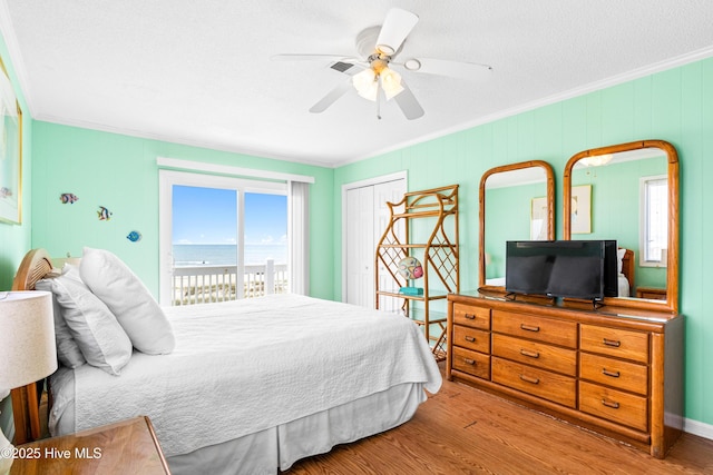 28 E First St Unit 4B, Ocean Isle Beach, NC 28469 - bedroom with ornamental molding, wood finished floors, access to outside, a closet, and ceiling fan