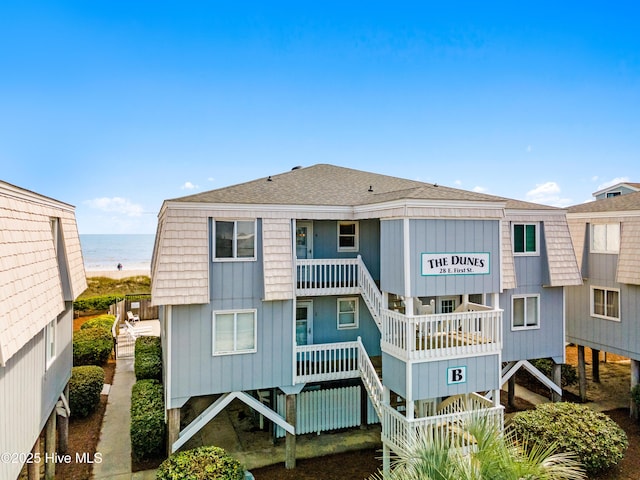 28 E First St Unit 4B, Ocean Isle Beach, NC 28469 - back of house featuring stairs, view of water and beach, and roof with shingles