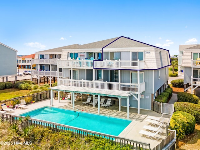 28 E First St Unit 4B, Ocean Isle Beach, NC 28469 - rear view of house with a patio, a balcony, a community pool, and fence