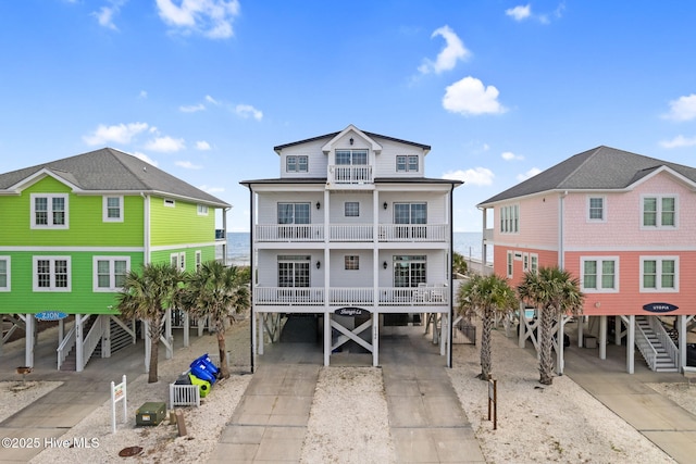 2721 W Beach Dr, Oak Island, NC 28465 - view of front of house with a carport, a balcony, stairway, and driveway