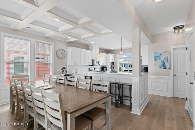 2721 W Beach Dr, Oak Island, NC 28465 - dining space with beamed ceiling, light wood-style flooring, coffered ceiling, wainscoting, and recessed lighting