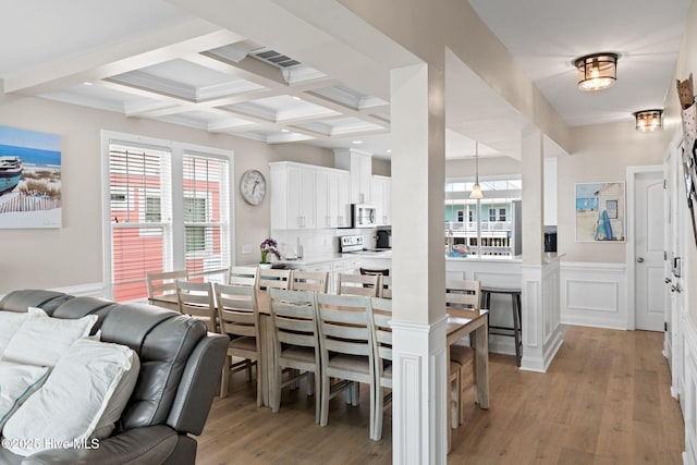 2721 W Beach Dr, Oak Island, NC 28465 - dining space featuring light wood finished floors, beamed ceiling, coffered ceiling, and a wainscoted wall