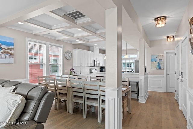2721 W Beach Dr, Oak Island, NC 28465 - dining space featuring beamed ceiling, light wood-type flooring, coffered ceiling, a wainscoted wall, and a decorative wall
