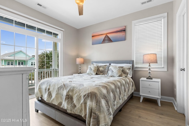 2721 W Beach Dr, Oak Island, NC 28465 - bedroom with wood finished floors, baseboards, ceiling fan, and access to exterior