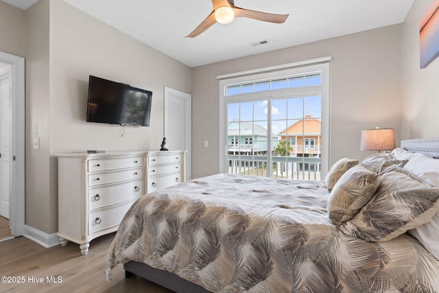 2721 W Beach Dr, Oak Island, NC 28465 - bedroom featuring light wood-type flooring, access to outside, baseboards, and ceiling fan