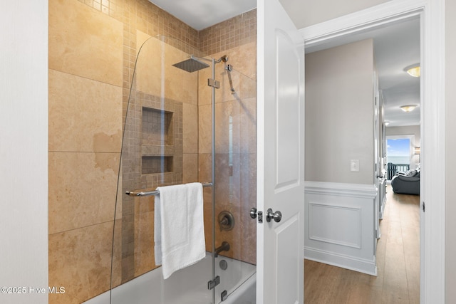 2721 W Beach Dr, Oak Island, NC 28465 - full bathroom with shower / bath combination with glass door, wood finished floors, and wainscoting