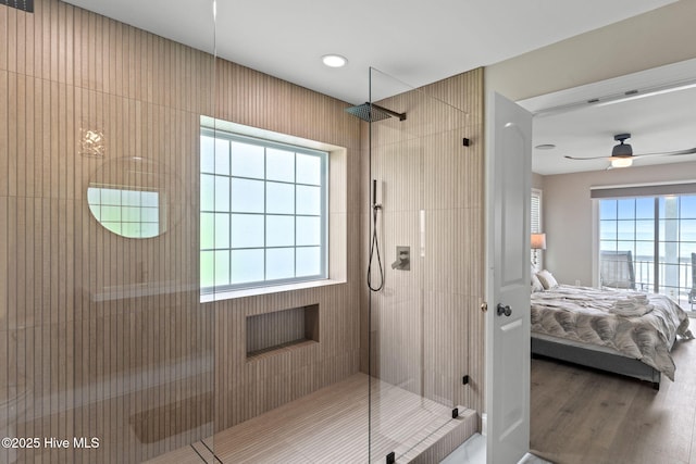 2721 W Beach Dr, Oak Island, NC 28465 - bathroom featuring connected bathroom, a tile shower, ceiling fan, and wood finished floors