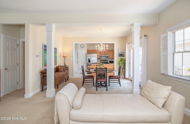 102 Macgregor Dr, Beaufort, NC 28516 - living room featuring light carpet, decorative columns, a chandelier, and healthy amount of natural light