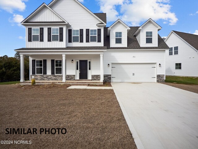 view of front facade featuring stone siding, concrete driveway, an attached garage, board and batten siding, and a porch