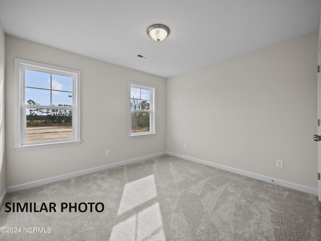 unfurnished room featuring carpet flooring and baseboards