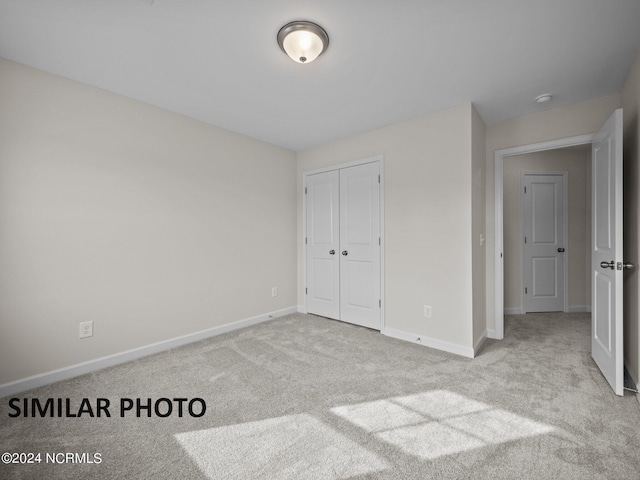 unfurnished bedroom featuring carpet floors, a closet, and baseboards