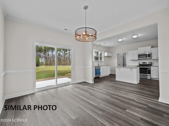 unfurnished living room with a chandelier, healthy amount of natural light, crown molding, dark wood-type flooring, and baseboards