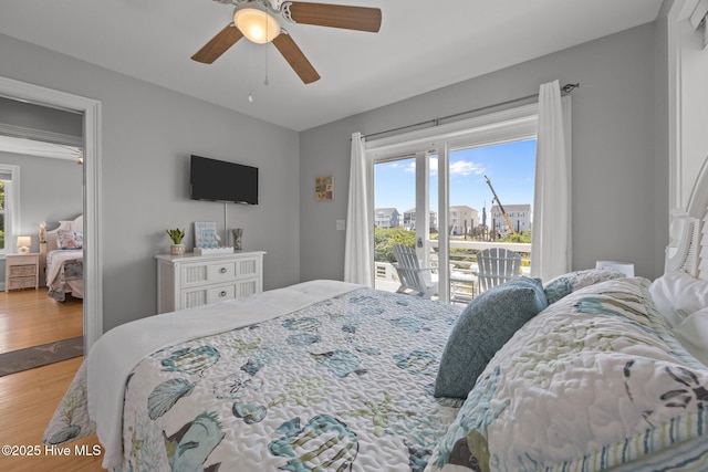 bedroom featuring access to exterior, wood finished floors, and ceiling fan
