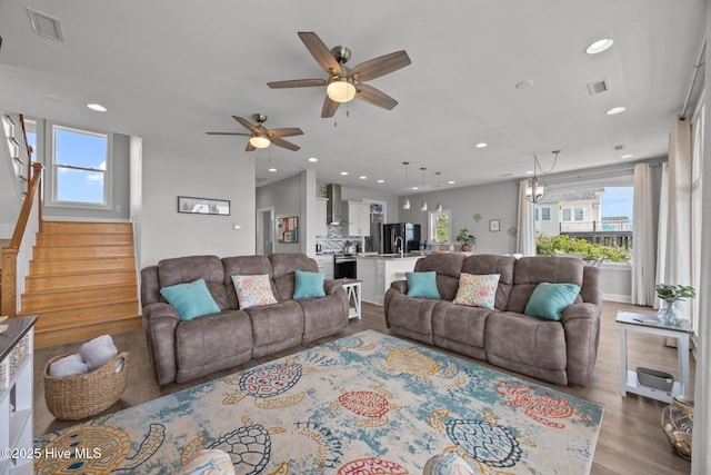 living room with wood finished floors, recessed lighting, stairs, and a ceiling fan