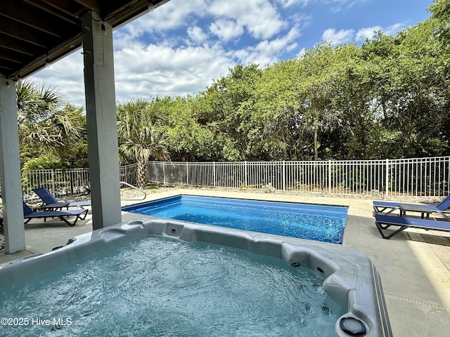 view of swimming pool featuring a patio area, a fenced backyard, and a hot tub